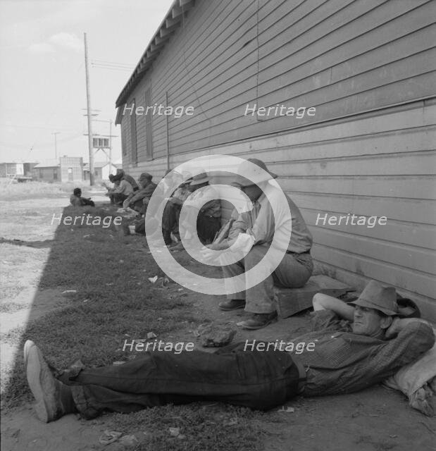 Idle men seated in shade on the other side of..., Tulelake, Siskiyou County, California, 1939. Creator: Dorothea Lange.