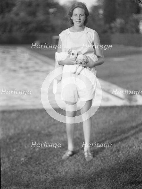 Rossbach, Miss, holding puppies, standing outdoors, 1932 June 30. Creator: Arnold Genthe.