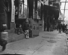 Three children in front of a cellar door, Chinatown, San Francisco, between 1896 and 1906. Creator: Arnold Genthe.