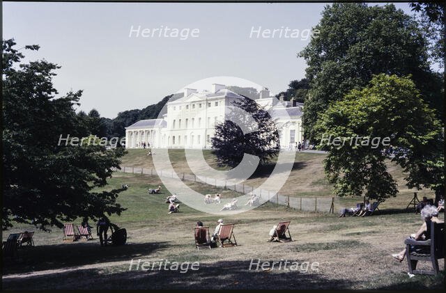 A view from the south-east looking towards Kenwood House, with people relaxing on the lawn..., 1984. Creator: Dorothy Chapman.