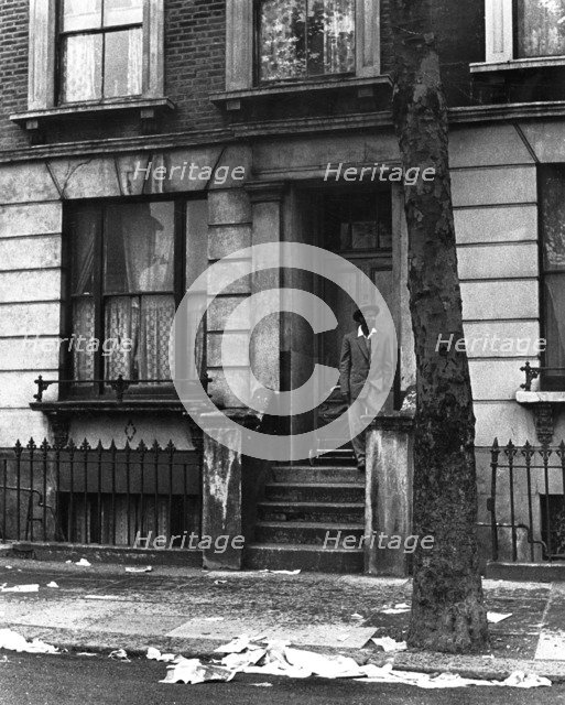 A man standing outside a house in Westbourne Grove, possibly in Kensington, London, 1950s. Creator: Henry Grant.