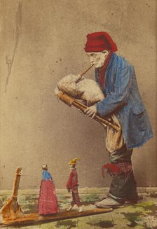 Unidentified man in cap playing a bagpipe-type instrument with two marionettes, about 1870. Creator: Giorgio Conrad.