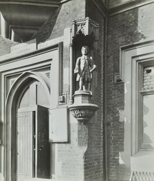 Statue of a boy scholar beside the door, Hamlet of Ratcliff Schools, Stepney, London, 1945. Artist: Unknown.