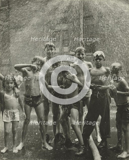 Group of children, mostly boys, gathered under sprinkler, in East Harlem, New York City, 1947 - 1951 Creator: Romulo Lachatanere.