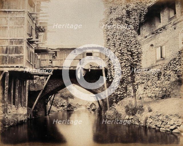 Kashmir: a built-over bridge on a canal betweeen houses, c1870s. Creator: Samuel Bourne.