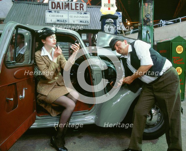 Mechanic with lady driver doing her make up, 1930's Hillman Minx. Artist: Unknown.
