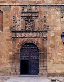 Front door of St. Peter's Cathedral, crowned by the seated image of Saint Peter Pope, embedded in…