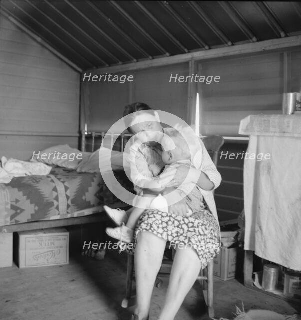 Mother from Oklahoma tends baby with dysentery, FSA camp, Tulare County, CA, 1939. Creator: Dorothea Lange.
