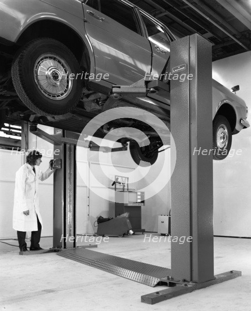 A Ford Zodiac on a Laycock asymmetric lift, 1972.  Artist: Michael Walters