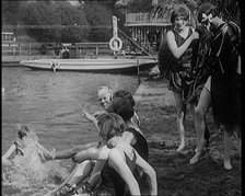 A Group of Young Female Civilians Wearing Swimsuits Playing on Riverside, 1920. Creator: British Pathe Ltd.
