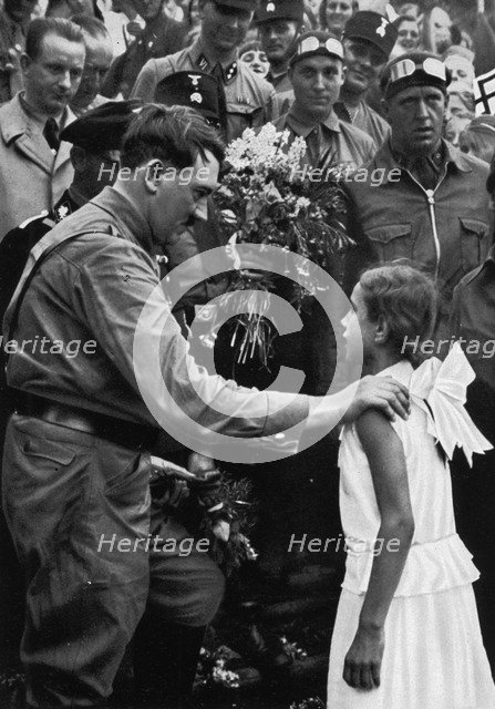 Adolf Hitler talking with a young girl during his election campaign, 1932. Artist: Unknown