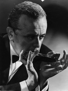 Larry Adler (1914-2001), Musician, playing his harmonica, c1940s. Artist: Unknown