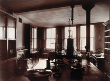 The interior of a pharmaceutical or chemical laboratory, with two long benches in the centre, glass. Creator: Unknown.