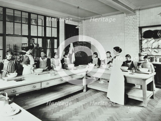 Student teacher in a cookery lesson, Battersea Polytechnic, London, 1907. Artist: Unknown.