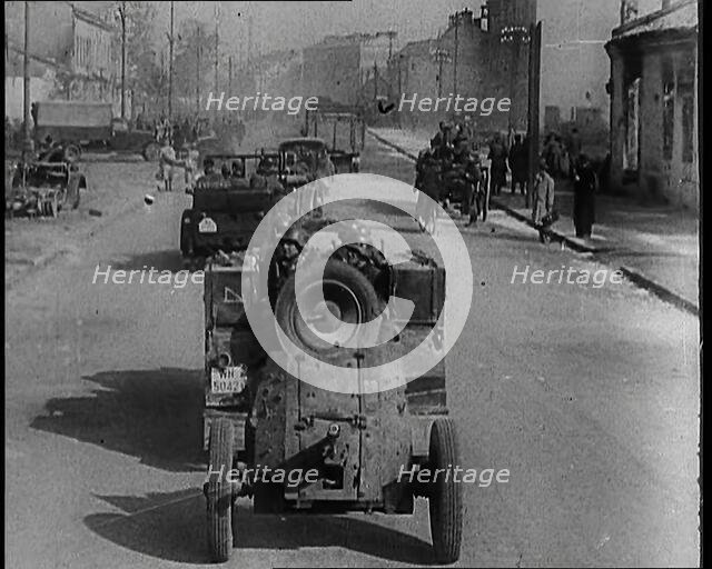 German Army Vehicles With Male Soldiers in Them Driving Down a Street in Warsaw Past..., 1939. Creator: British Pathe Ltd.