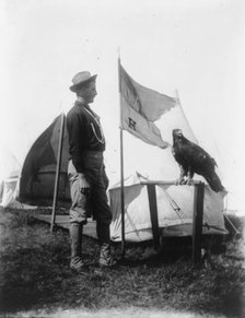 Soldier and eagle mascot beside "H" Troop flag, 1898. Creator: Frances Benjamin Johnston.