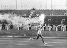 The Olympic flame entering the Olympic Stadium, Tokyo, 10 October 1964. Artist: Unknown