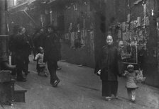 Woman and a child walking down a street, Chinatown, San Francisco, between 1896 and 1906. Creator: Arnold Genthe.