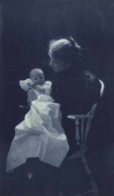 Woman, sitting in chair, holding an infant, full-length portrait, c1900. Creator: Sarah J. Eddy.