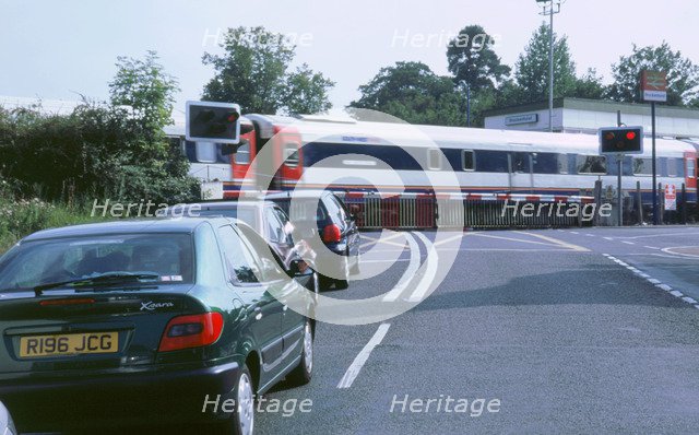 Traffic queue at level crossing in Brockenhurst, Hampshire. Artist: Unknown.