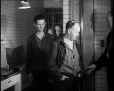 A group of Male Americans Civilians Wearing Prisoners Outfits Being Escorted Into a Room..., 1930. Creator: British Pathe Ltd.