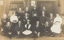 Sailors, some in drag, posing for a group portrait within a highly...(between 1910 and 1919?). Creator: Unknown.