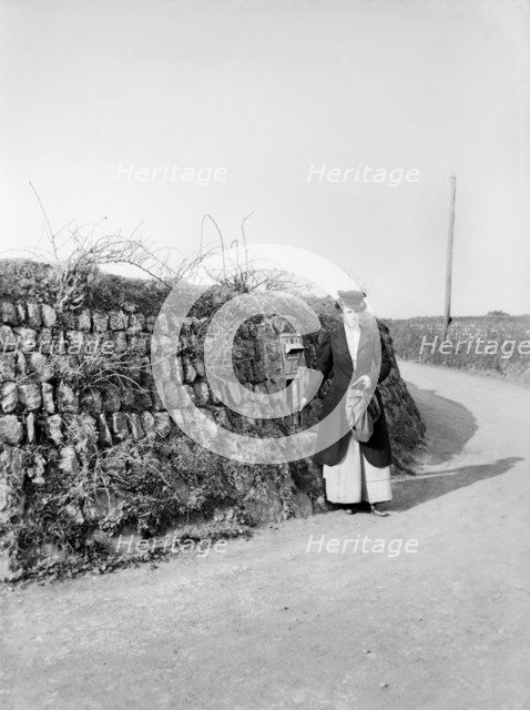 Postwoman emptying a postbox at an unidentified location in Kerrier, Cornwall, 1901. Artist: Alfred Newton & Sons.