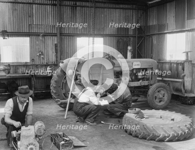 Laing workers carrying out maintenance work on the a Fordson Major Diesel Tractor, 22/07/1959. Creator: John Laing plc.
