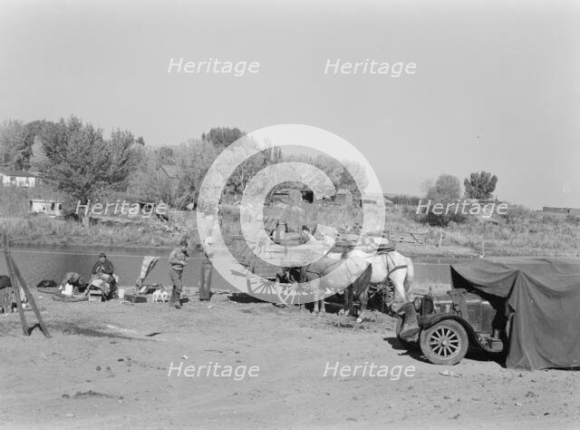 Migrant family cleaning up, near Vale, Malheur County, Oregon, 1939. Creator: Dorothea Lange.