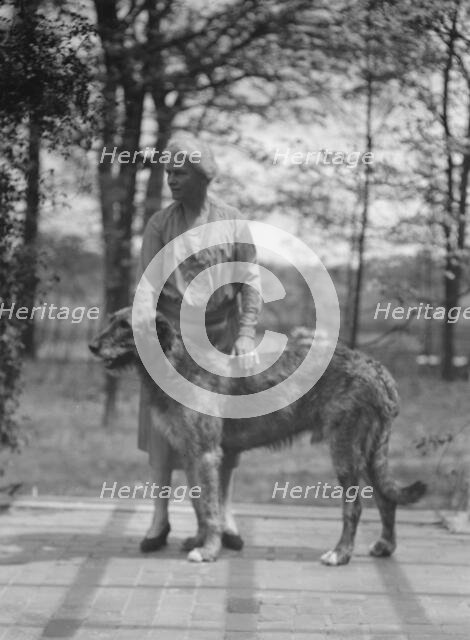 Noland, Charlotte, Miss, with dog, standing outdoors, 1931 May 8. Creator: Arnold Genthe.