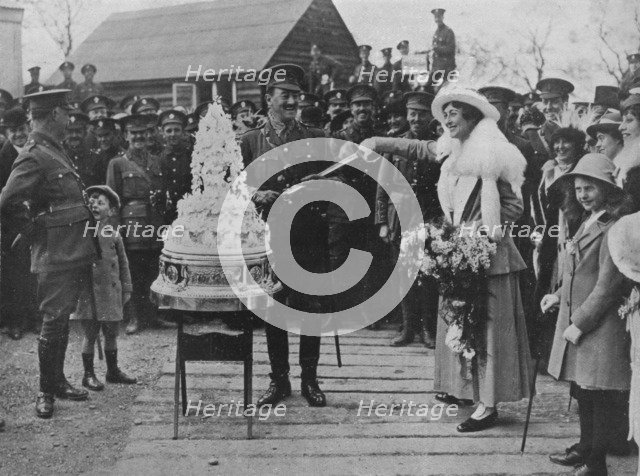 'A khaki wedding: Cutting the wedding cake with the bridegroom's sword', 1915. Artist: Unknown.