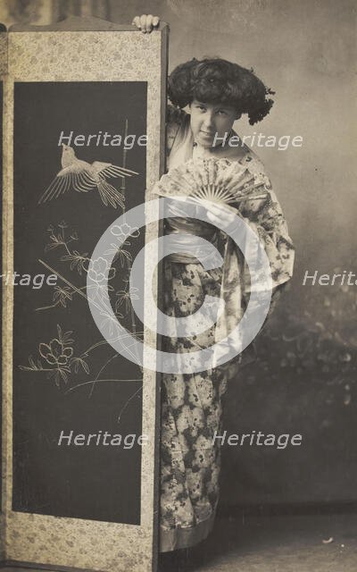 A man wearing a kimono posing from behind a screen, 1906. Creator: Unknown.