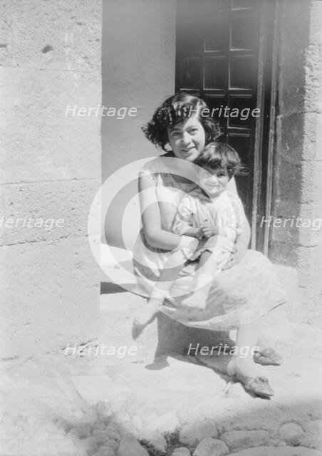 Cenerini, Mrs., and child, seated on a doorstep, 1929 Creator: Arnold Genthe.