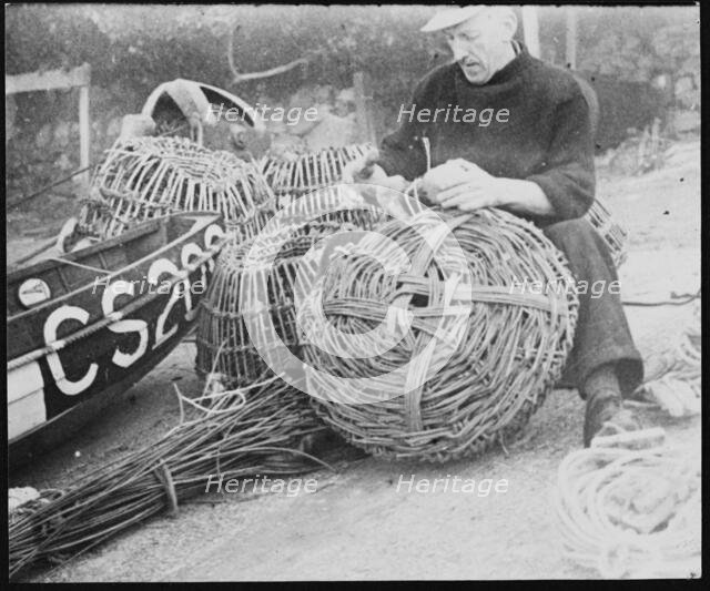 A fisherman making lobster pots at Steephill Cove, Ventnor, Isle Of Wight, 1930-1950. Creator: George R Long.