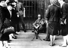 Civilians in front of a German guard post with a machine gun, Paris, June 1940. Artist: Unknown