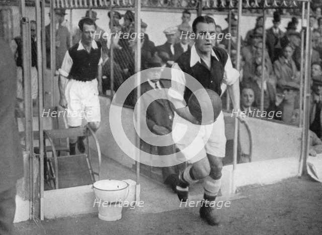 Arsenal FC captain Eddie Hapgood runs onto the pitch at Highbury, London, 1930s. Artist: Barratt's Photo Press Ltd