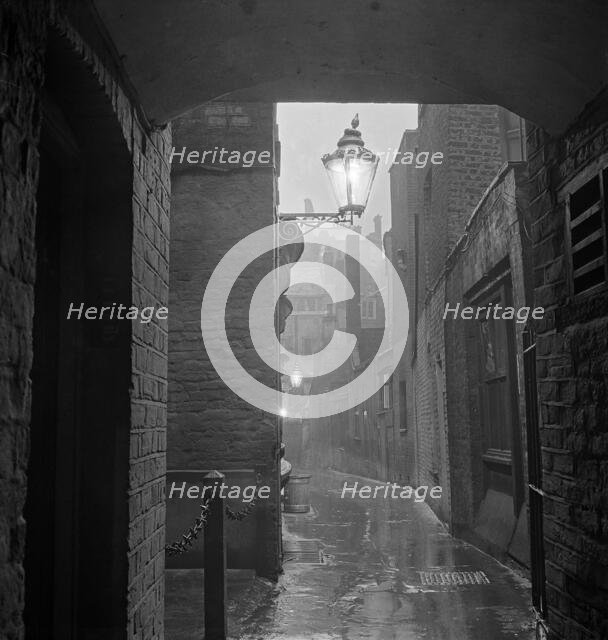 A dimly lit alley in London's theatre land off St Martin's Lane, early 1960s.  Creator: John Gay.