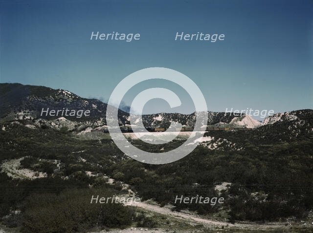 Freight train with two helper engines climbing the steep grade of Cajon Pass (westbound), CA., 1943. Creator: Jack Delano.