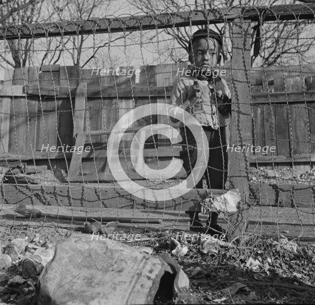 Boy playing in the backyard of his home, Washington (southwest section), D.C., 1942. Creator: Gordon Parks.