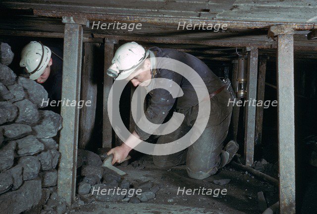 Loading coal onto a conveyer.