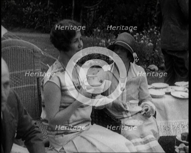 A Group of People Drinking Tea and Eating Cakes in the Garden, 1926. Creator: British Pathe Ltd.