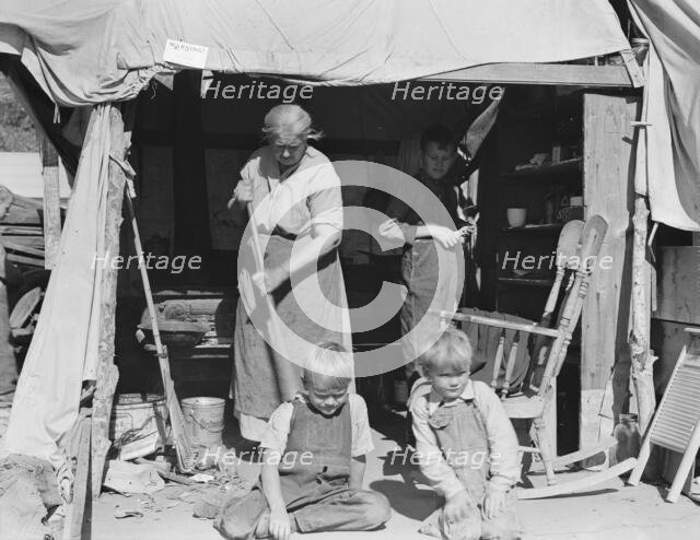 Aged woman with three of her twenty-two grandchildren, Kern county migrant camp, California, 1936. Creator: Dorothea Lange.