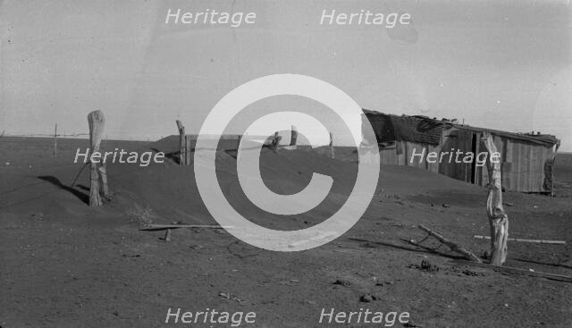 Fence corner and outbuilding being buried by dust, Mills, New Mexico, 1935. Creator: Dorothea Lange.