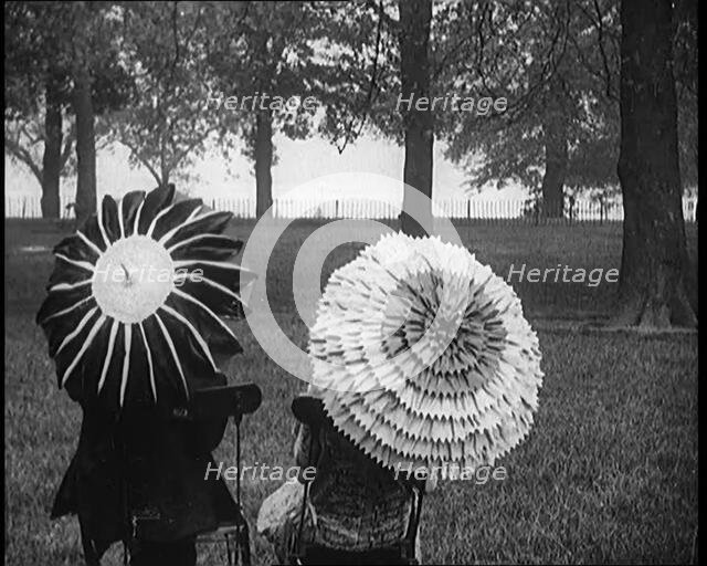 Female Civilians Holding Ornate Parasols in a Park, 1920. Creator: British Pathe Ltd.