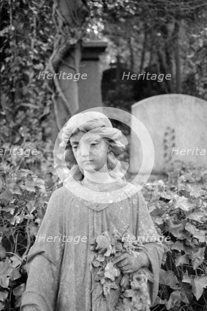 Statue of a girl holding flowers, Highgate Cemetery, Hampstead, London, 1995. Artist: John Gay.