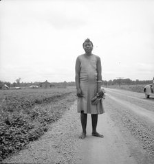 Negro woman carrying her shoes home from church, Mississippi Delta, 1936. Creator: Dorothea Lange.
