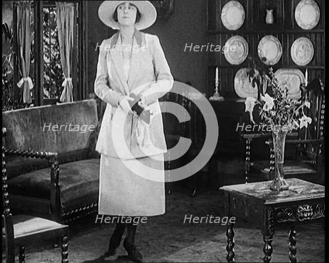 A Female Civilian Modelling a Two Piece Suit and Hat Posing in a Drawing Room, 1920. Creator: British Pathe Ltd.