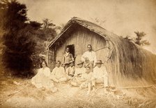 New Zealand: a group of Maori sitting in front of a traditional house, between 1800 and 1899. Creator: Unknown.