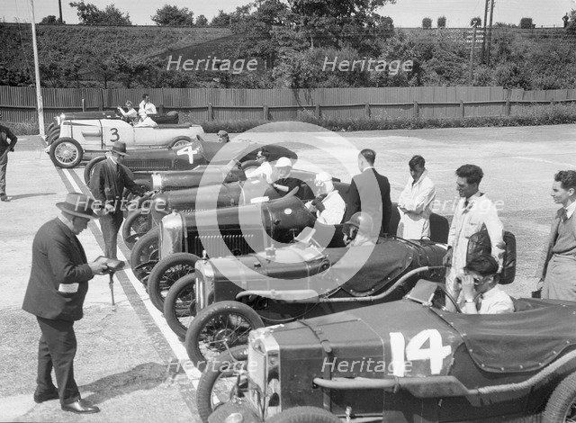 Cars on the start line for a motor race at Brooklands. Artist: Bill Brunell.