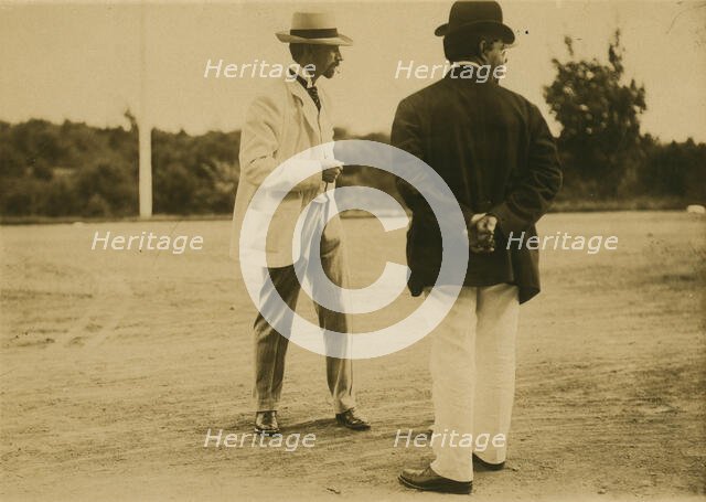Two men, probably journalists, standing on a field, 1905. Creator: Unknown.